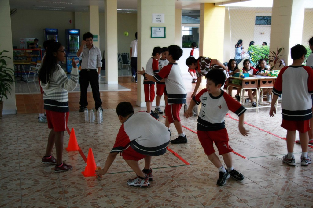 A group of students playing “Bottle Bowling,” organized by Grade 5 students