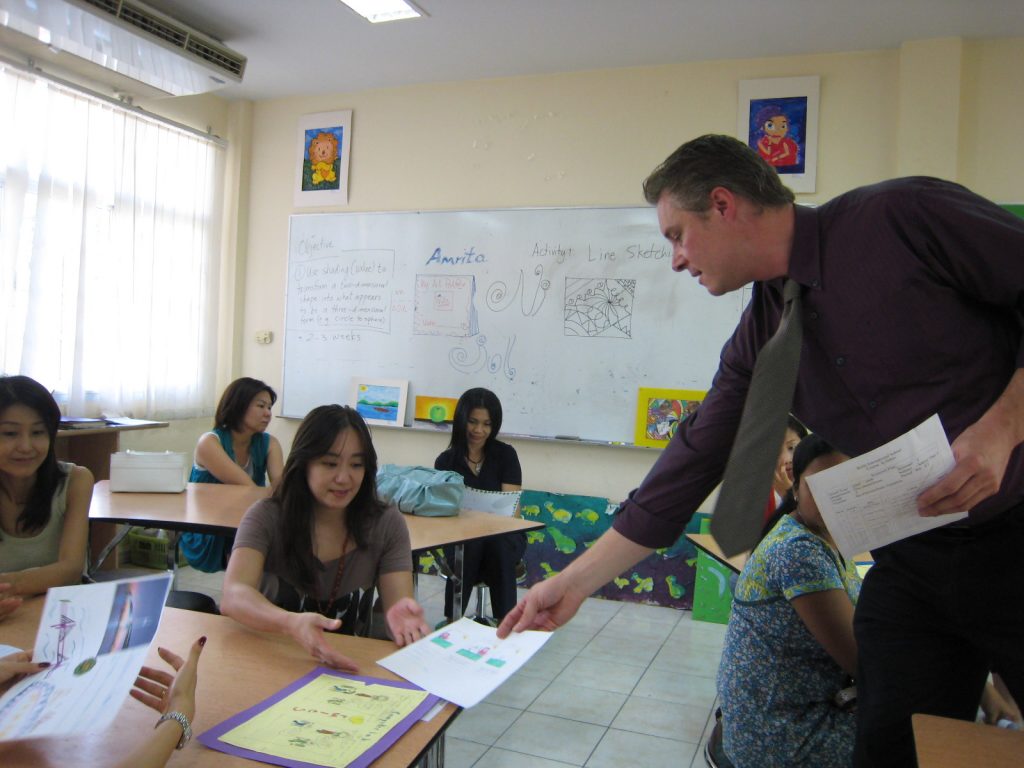 Grade 2 teacher sharing student work with parents, giving insight to parents into what kind of learning takes place in his classes