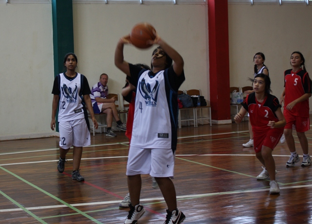 Power forward Ramita Sachasiri (gr 8) lays one with twin sister Richika backing her up.