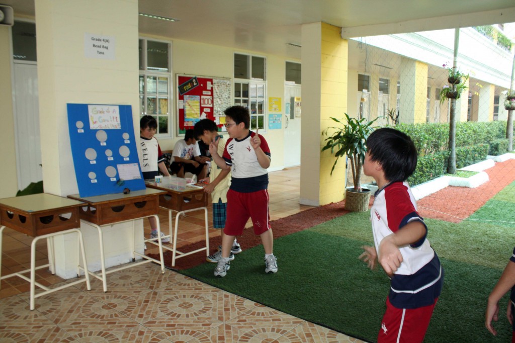 A student aiming to hit the bean bag in the correct spot, an activity organized by Grade 4A students