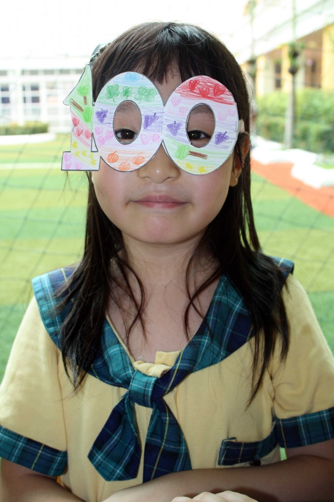 A grade one student showing her colorful pair of “100 glasses” 